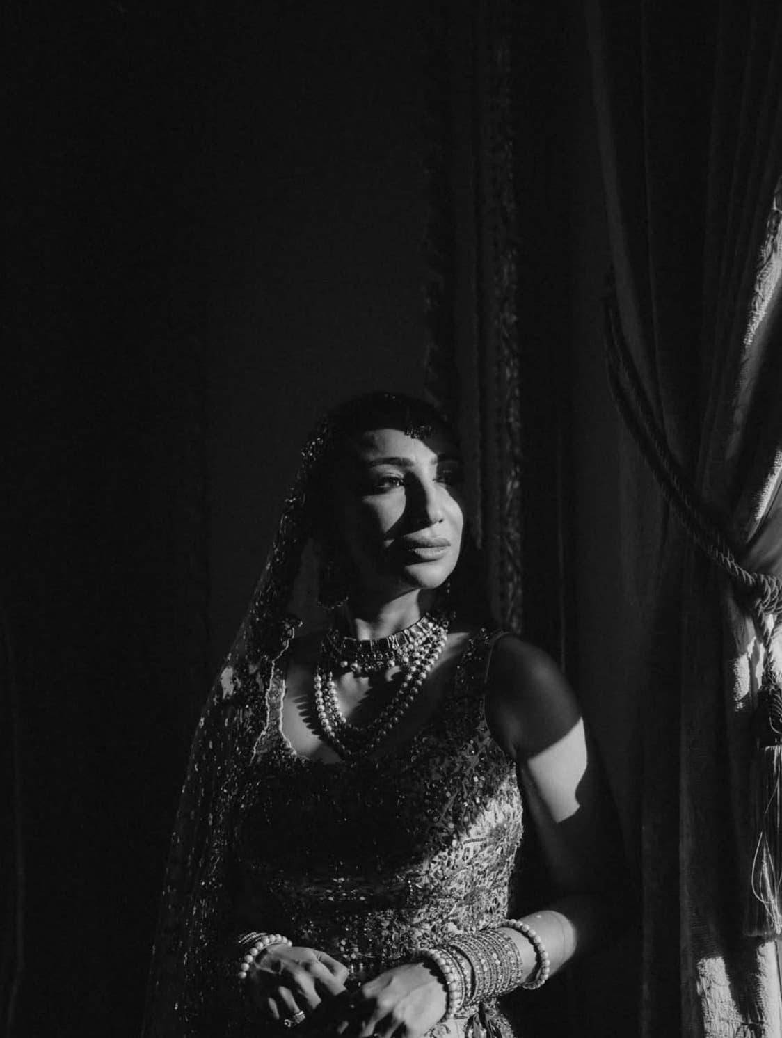 A bride in black and white, lit by a single window